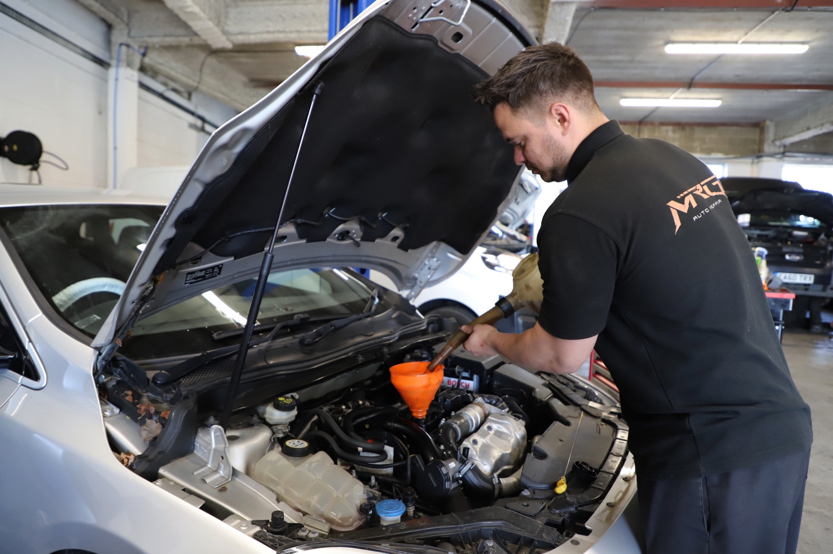 Mechanic cleaning and servicing a vehicle - Car Servicing Poole